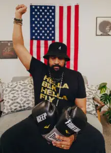 Reggie Hubbard in front of an American flag with his fist raised