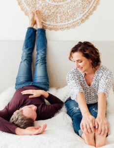 Jason Crandell and Andrea Ferretti sitting on a bed