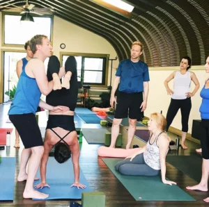 Jason Crandell assisting in scorpion yoga pose