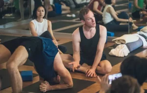 Jason teaching a yoga student in Viparita Dandasana