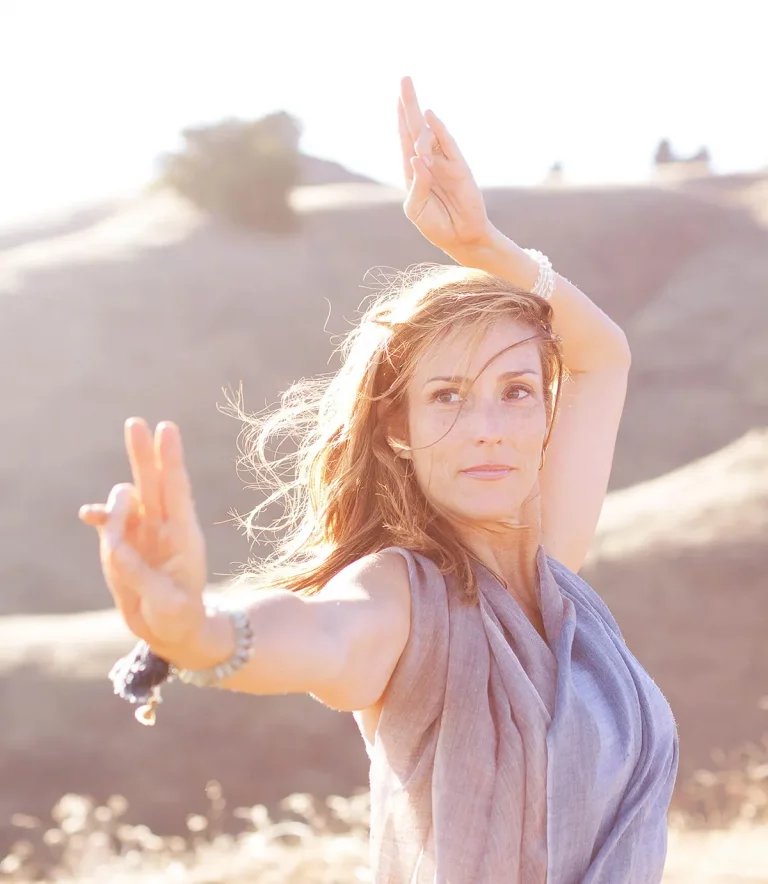 Stephanie Snyder outside in sunshine, in a yoga pose